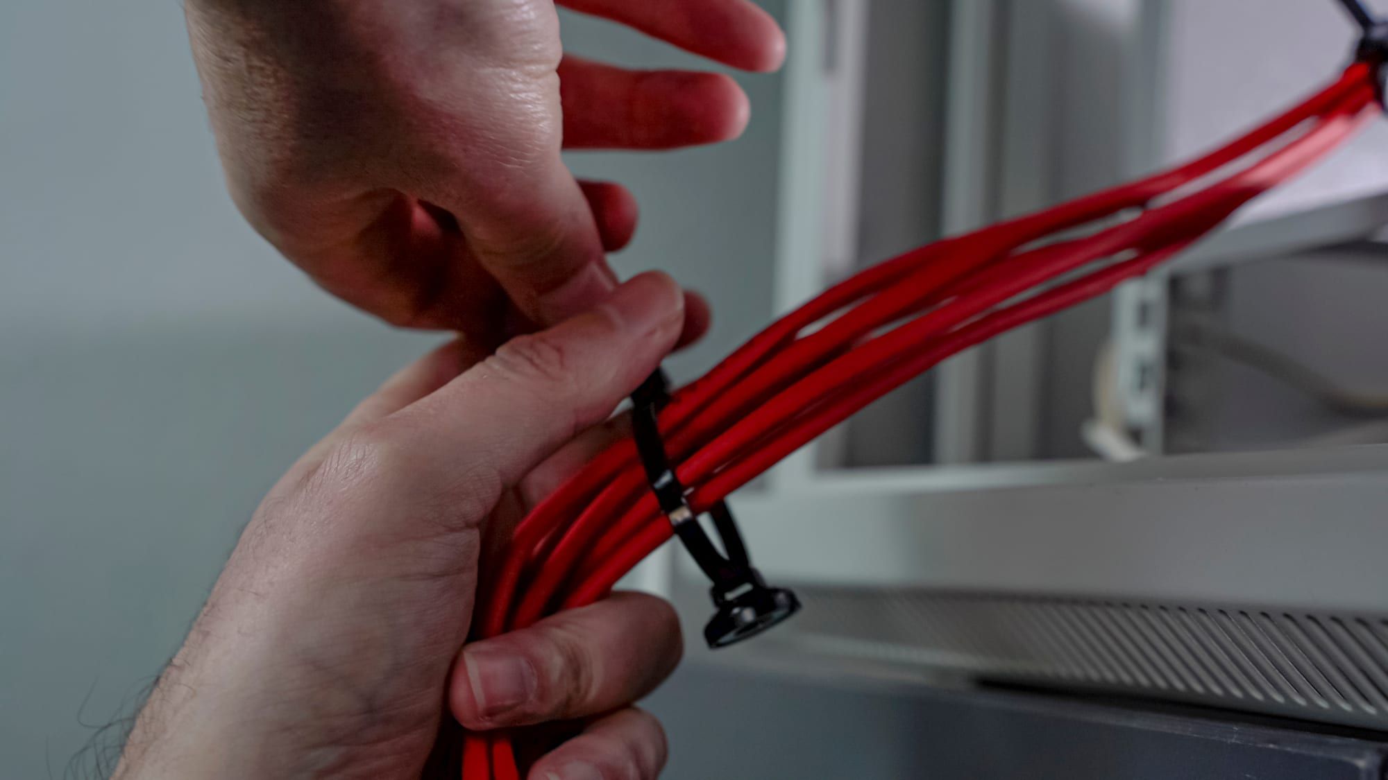 Red cables being zip-tied to a magnetic mount